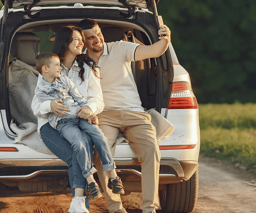 A family relaxing in the open back of their car