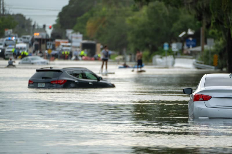 Cars driving through a flooded street during a storm